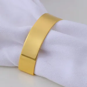 Polished gold semi-circle napkin ring with letter D shape on a white fabric napkin