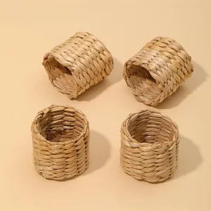 Detalle de cuatro servilleteros artesanales hechos de cáscara de maíz y jacinto de agua