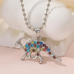 Detail of a dinosaur pendant necklace with colorful rhinestones on a white display stone