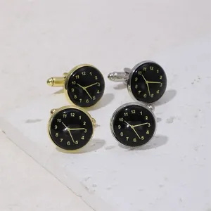 Vue macro de boutons de manchette horloge en or et argent sur fond de pierre blanche
