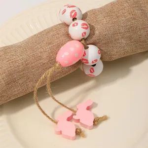 Dettaglio portatovagliolo pasquale con perle di legno e ciondoli a coniglietto rosa