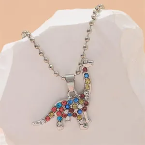 Detailed view of dinosaur pendant featuring colorful rhinestones on a silver bead chain