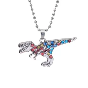 Detail of colorful rhinestone-encrusted T-Rex pendant necklace with silver bead chain