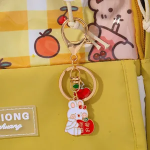 Detail of yellow backpack with cute rabbit keychain and lucky apple charm accessory