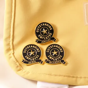 Detail view of round black and gold enamel pins for Outstanding Employee of the Month