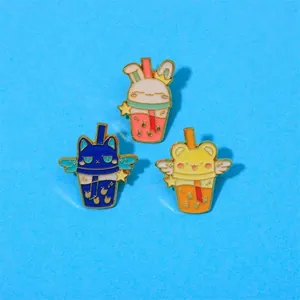 Close-up of cute cartoon milk tea cup enamel pins with rabbit ears and gold trim