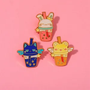 Detailed close-up of three cute enamel pins featuring animals in milk tea cups