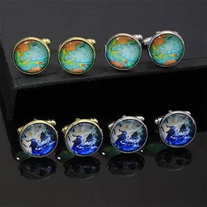 Detail view of round world map cufflinks with gold and silver finish and crystal accents
