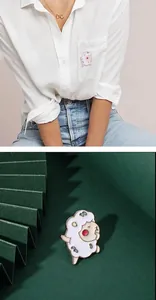 Detail showing cartoon sheep enamel pin on a model's outfit and on a dark green background