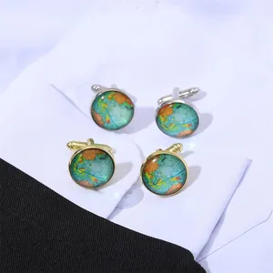 Macro detail of gold and silver world map cufflinks set on elegant tuxedo suit sleeve