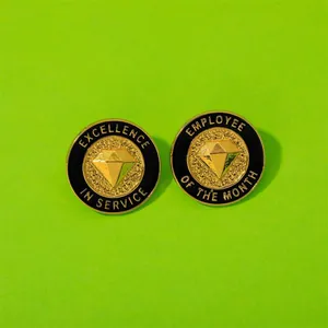 Gouden speldjes voor medewerker van de maand en uitmuntende service met diamant
