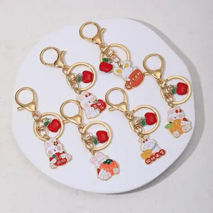 Set of 6 cartoon bunny metal keychains with festive lucky symbols on a white plate