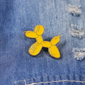 Simpatico cane palloncino giallo spilla smaltata su sfondo denim blu