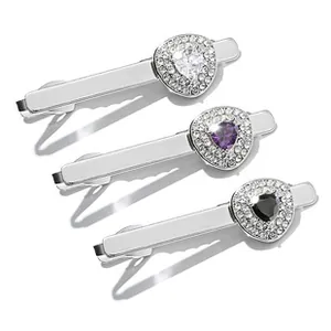 Detail of silver tie clips with heart-shaped gemstones and sparkling diamond accents