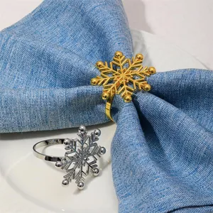 Close-up of elegant gold and silver snowflake napkin rings on blue fabric