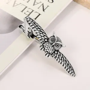 Detailed macro view of vintage silver owl-shaped metal tie clip with intricate feather texture