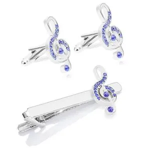Macro shot of silver music treble clef cufflinks and tie clip set with blue crystals