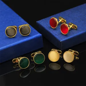 Detalle de gemelos de circón multicolor con borde dorado y centro con efecto ojo de gato