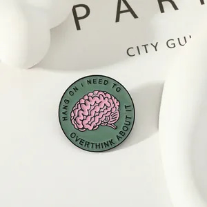Spilla rotonda in smalto rosa e verde con citazione sulla salute mentale creativa