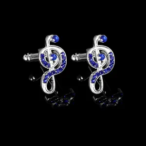 Detail view of silver treble clef cufflinks with sparkling blue crystals on black background
