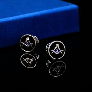 Macro view of Masonic compass and square cufflinks with crystal on black reflective surface