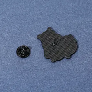 Dettaglio del retro della spilla smaltata con trama antiscivolo e chiusura a farfalla