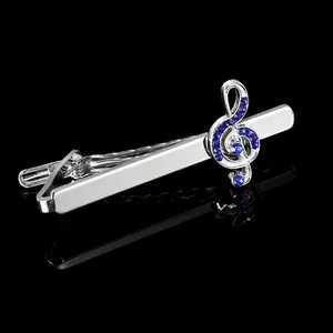 Detail showing music note tie clip with blue crystals on a reflective black background