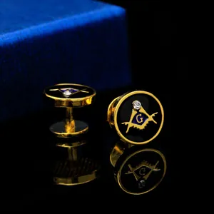 Macro view of gold Freemasonry cufflinks with black enamel and blue compass G logo