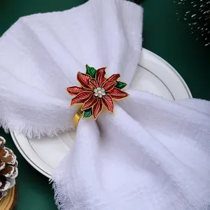 Macro detail of red poinsettia napkin ring with rhinestones on a white festive napkin