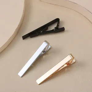Vue détaillée de pinces à cravate minimalistes en noir mat, argent et or rose poli