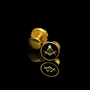 Detailed close-up of golden Freemasonry cufflinks with black enamel and G emblem