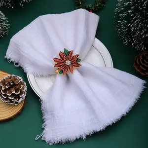 Close-up of a festive red poinsettia napkin ring with gold edges and white rhinestones