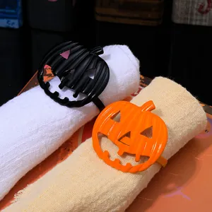 Detail view of black and orange enamel pumpkin napkin rings for Halloween table decor