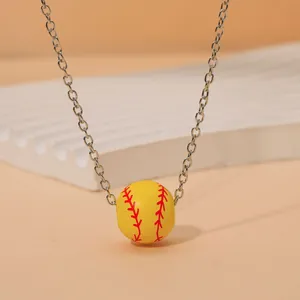 Vue détaillée du pendentif balle de softball jaune avec coutures rouges et chaîne argentée