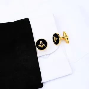 Macro shot of gold Masonic cufflinks with black enamel and G symbol on a white shirt