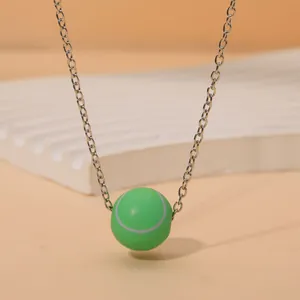 Gros plan du pendentif balle de tennis verte avec chaîne en métal argenté