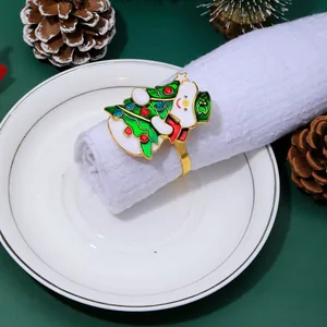 Close-up of enamel Christmas tree napkin ring with colorful stones on white napkin