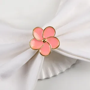 Dettaglio macro di un elegante portatovaglioli a fiore smaltato rosa con placcatura oro