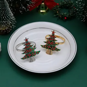 Detail of green enamel Christmas tree napkin ring with red rhinestones on festive table