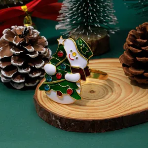 Detailed view of snowman and Christmas tree napkin ring on a rustic wooden base