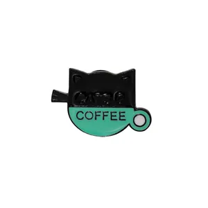 Close-up of mint green coffee cup and black cat enamel pin with Cats & Coffee text