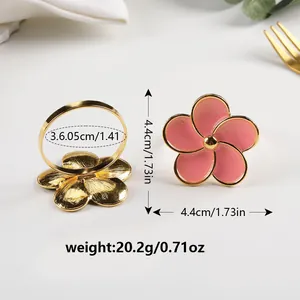 Set di portatovaglioli dorati con fiori in smalto rosa per una tavola elegante e raffinata