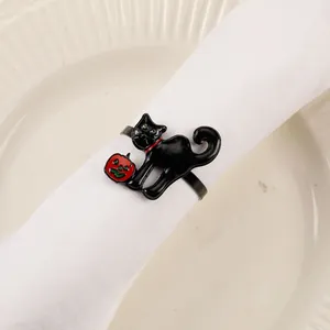 Detail of Halloween napkin ring with black cat and red pumpkin on white fabric