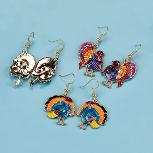 Detail of turkey-shaped alloy earrings in gold and colorful enamel finishes for Thanksgiving