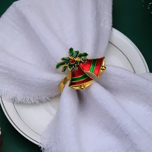 Christmas napkin ring with red gold bells and green holly leaves on white napkin