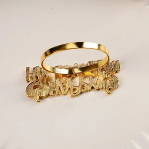 Detailed view of a golden metal Thanksgiving napkin ring with Happy Thanksgiving cursive text