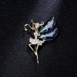 Detail of a gold ballet girl brooch featuring purple wings and sparkling rhinestones