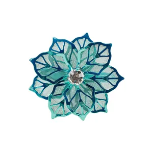 Detalle del servilletero de flor azul con pétalos de malla y una gema central brillante