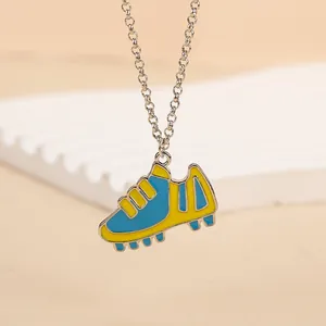 Détail du pendentif chaussure de foot bleu et jaune avec chaîne argentée élégante