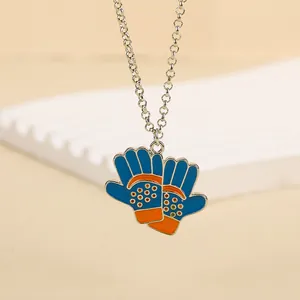 Vue détaillée du pendentif en alliage avec gant de sport bleu et orange sur chaîne argent